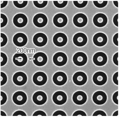 A portion of an array of annular shapes, each 450 nm in diameter, with a 1 µm spacing (pitch) between shapes.