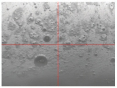 Intensity image of CD ROM surface with contaminants shown at 16X magnification through integrated 8X optics and 2X FOV modifier lens.