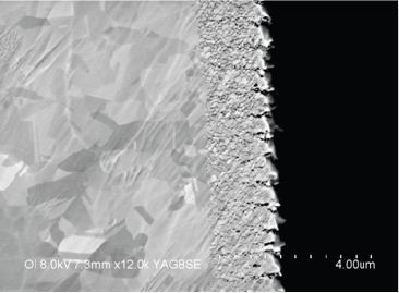 Higher magnification SEM Backscattered Image of the TSV interface with the silicon substrate. The scalloped region and porosity are seen