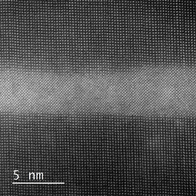 HAADF STEM image taken on a Cs corrected JEOL 2200FS. Conditions are 450 deg C and 10 mbar of N2 gas. This is a GaP/GaNAsP quantum well. GaP is the material on the top and bottom, and appears darker, GaNAsP is the material sandwiched in the center and appears lighter. This structure is used in quantum well lasers.