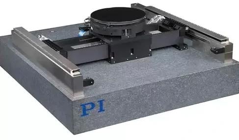 A 3-axis XY-Theta stage based on a gantry-type planar air bearing XY-table carrying an air bearing rotary table. The linear motor magnet tracks are mounted on the granite base, but due to the air bearing principle, there is no contact at all. Frictionless planar XY motion is possible with magnetic bearings, air bearings, and flexures and provides better geometric performance than stacked XY stages.