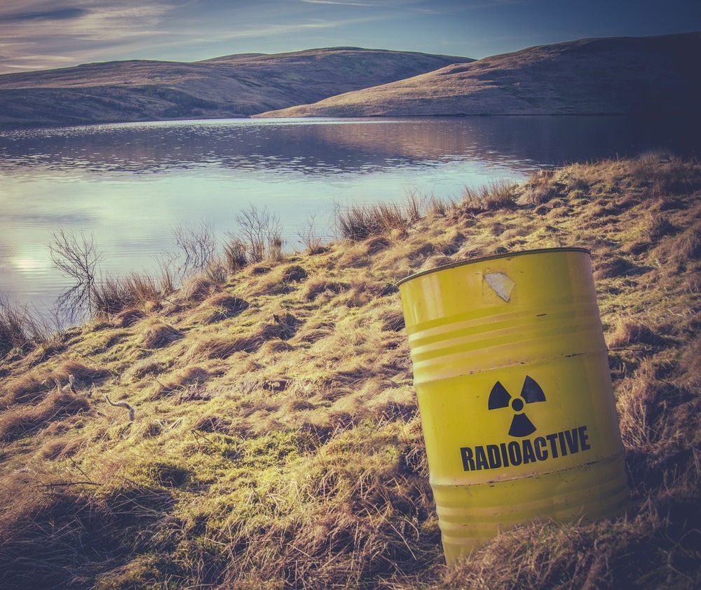 Conceptual Image Of A Radioactive Nuclear Waste Barrel Or Drum Near Water In The Countryside