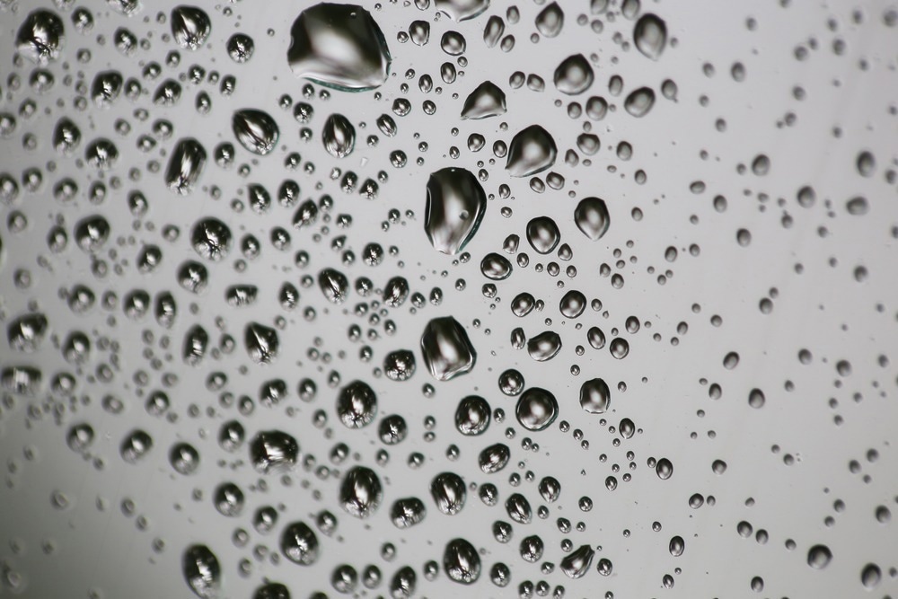 Macro shot of raindrops on a winder with refraction